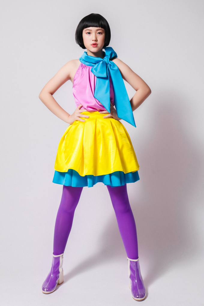 Nhà thiết kế Thanh Huỳnh kết hợp gam màu tương phản nóng - lạnh tạo ấn tượng thị giác cho trang phục. Phần chân váy xếp lớp và nơ to bản màu xanh nhấn nhá cho tổng thể.