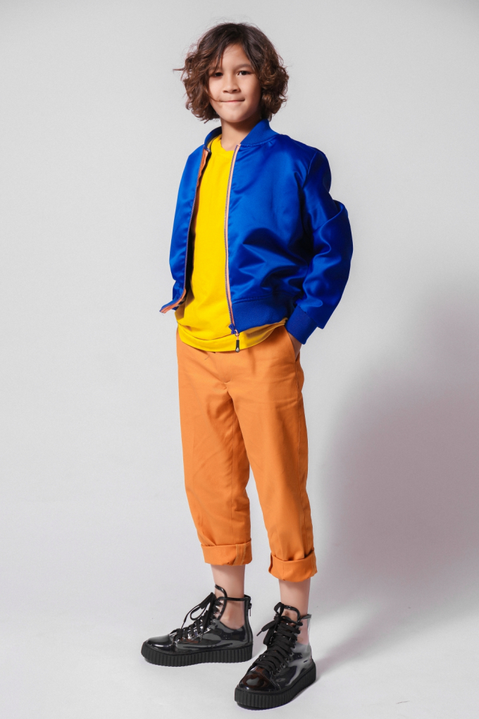 Kelvin thừa hưởng tình yêu thời trang từ mẹ là nhà thiết kế Thanh Huỳnh và bố là danh thủ bóng đá Kesley. Cậu bé có mái tóc lãng tử và gương mặt lai điển trai yêu thích bomber gam xanh. Trang phục đa sắc có thể ứng dụng cho các bé đi học, đi chơi.