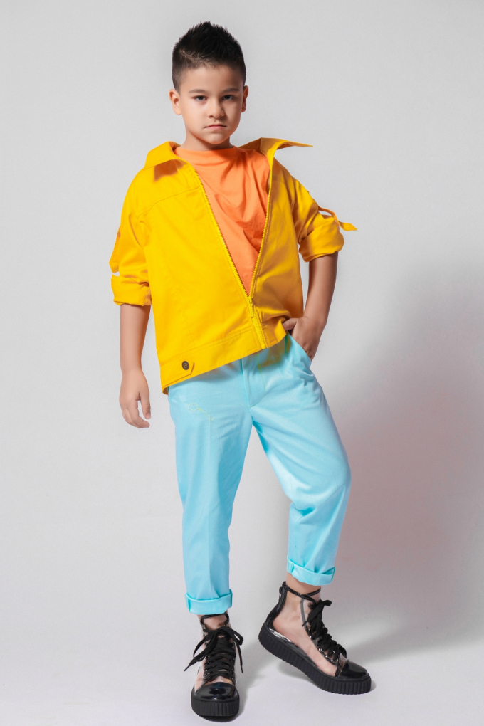 &nbsp;Kaylan - em trai Kelvin tuy nhỏ tuổi nhưng tự tin tạo dáng trước ống kính. Áo khoác ngoài tông vàng rực rỡ giúp Kaylan nổi bật giữa đám đông. Bên cạnh công việc mẫu nhí, hai anh em còn sở hữu nhiều tài lẻ như đánh trống, ca hát.